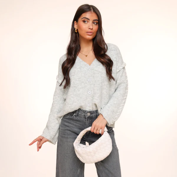 KLEDING-DONKERGRIJZE-WIJDE-DENIM-JEANS-SPIJKERBROEK-LICHTGRIJZE-NADEN-GEVLOCHTEN-VHALS-LANGE-MOUWEN-VEST-WITTE-GEVLOCHTEN-TAS-02_600x